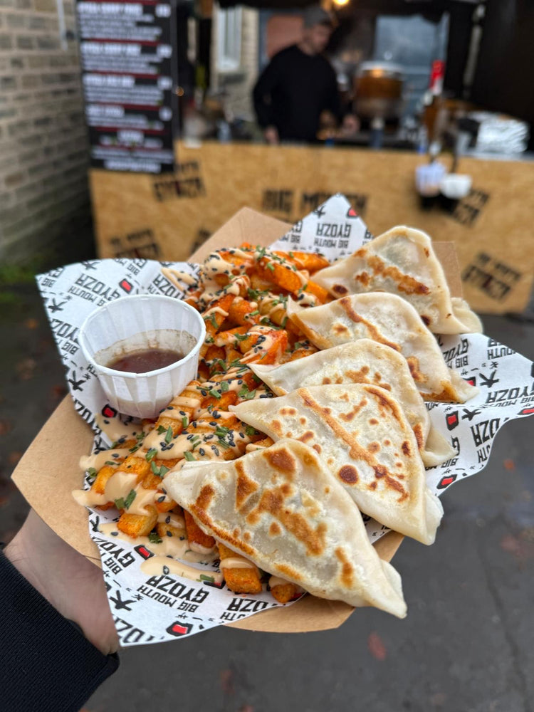 Gyoza loaded fries held up in front of the Big Mouth Gyoza stall