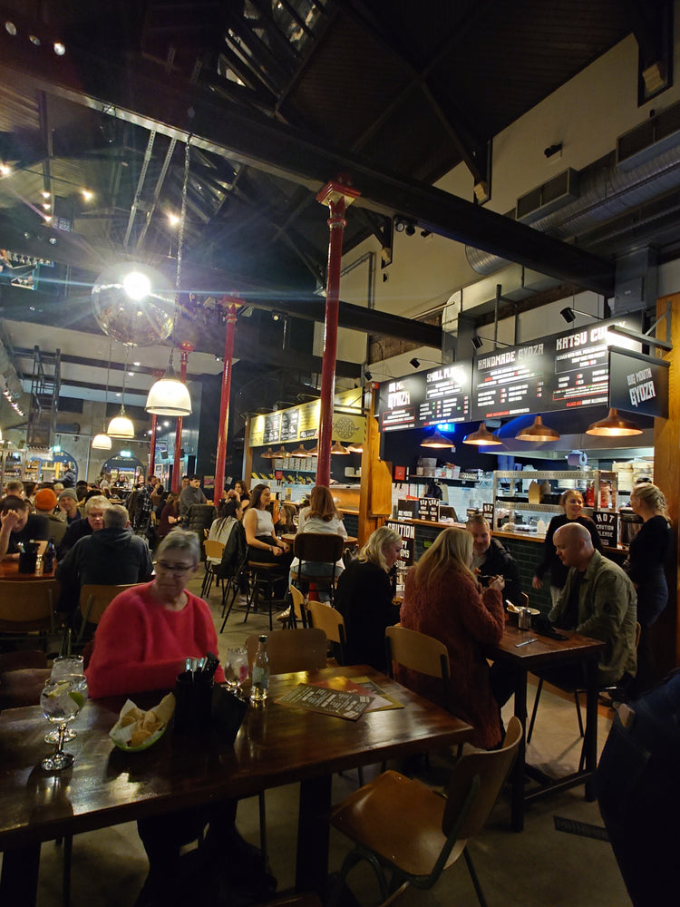 Diners eating in front of the Big Mouth Gyoza counter at The Produce Hall, Stockport