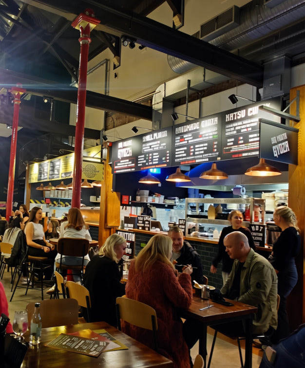 Diners eating in front of the Big Mouth Gyoza counter at The Produce Hall, Stockport
