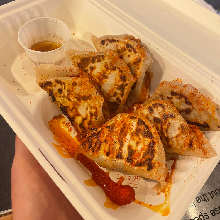 A tray of gyoza with chilli sauce
