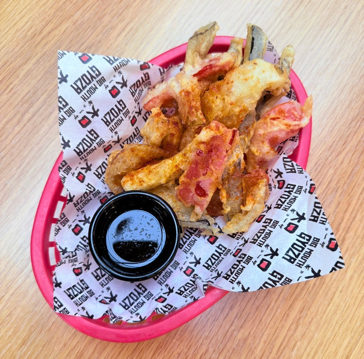 Tempura vegetables in a basket with dipping sauce